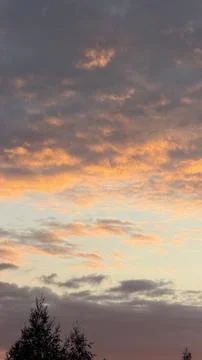 Dramatic sunset sky filled with textured clouds glowing in orange, pink, and Stock Photos