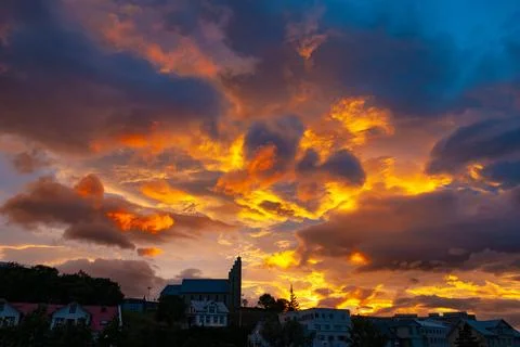 Dramatic sunset sky glowing above a large town church Stock Photos