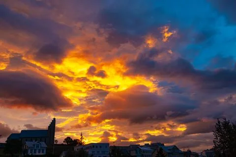 Dramatic sunset sky glowing above a large town church Stock Photos