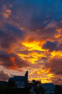Dramatic sunset sky glowing above a large town church Stock Photos