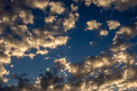 Dramatic sunset sky with golden clouds after thunderstorm Stock Photos