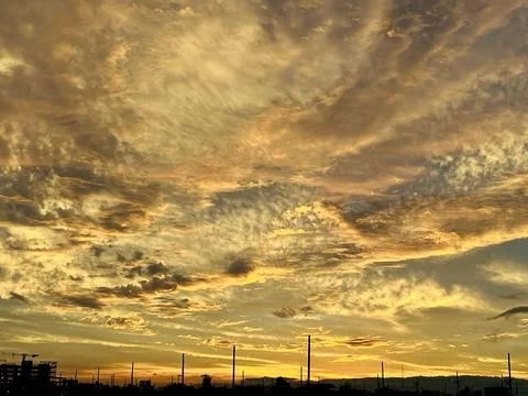 Dramatic Sunset Sky with Golden Clouds over Urban Horizon Stock-Fotos