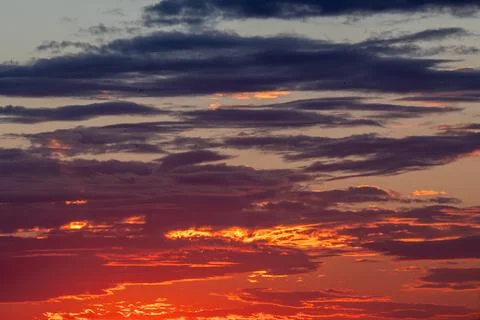 A dramatic sunset sky from high above, with richly textured clouds stretchi.. Stock Photos