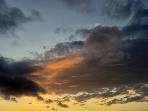 Dramatic sunset sky with layered clouds and warm glow Stock Photos