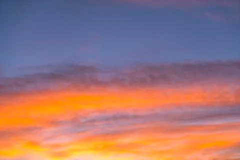 Dramatic sunset sky with orange colored clouds in summer season.. Stock Photos