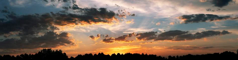Dramatic sunset sky with orange colored clouds and sun. Foto stock