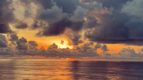 Dramatic sunset sky over a calm ocean with soft light reflections Stock Footage 338282760
