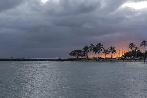 Dramatic sunset sky over the calm ocean water surface with silhouettes of p.. Stock Photos