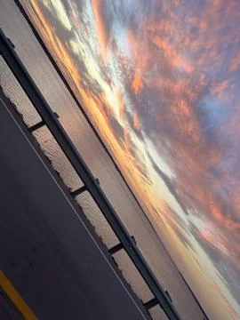 Dramatic sunset sky over coastal highway and calm water Stock Photos