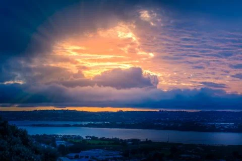 Dramatic sunset sky over dark waters of sea bay. Stock Photos