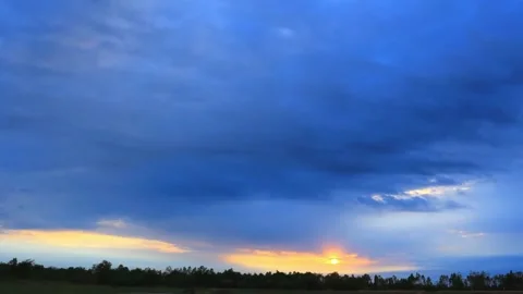 Dramatic Sunset Sky Over Flat Landscape with Silhouetted Trees Stock Footage 311528957