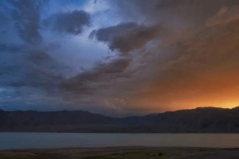 Dramatic sunset sky over a mountain lake with copy space. Universal nature ba Stock Photos