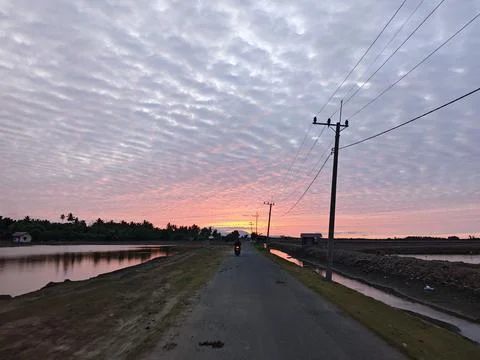 Dramatic Sunset Sky Over Rural Road and Ponds Stock Photos