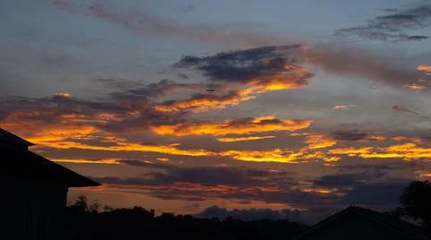 Dramatic Sunset Sky Over Silhouetted Rooftops 스톡 사진