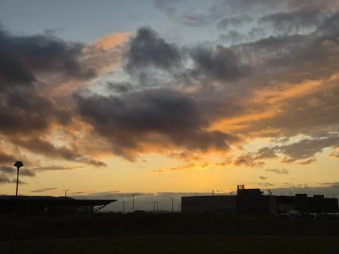 Dramatic sunset sky over silhouetted urban skyline Stock Photos