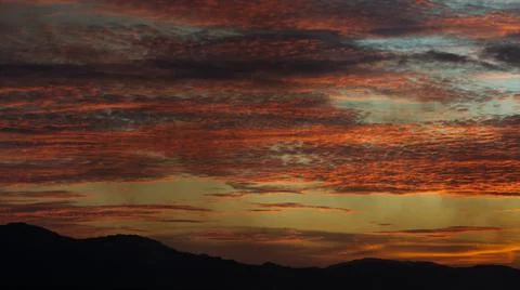 Dramatic Sunset Sky Over Silhouetted Mountains Stock Photos