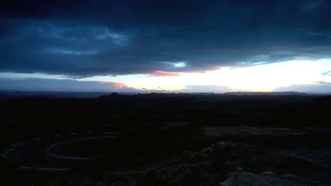 Dramatic sunset sky over a winding road in a mountainous landscape Stock-Footage 311819806