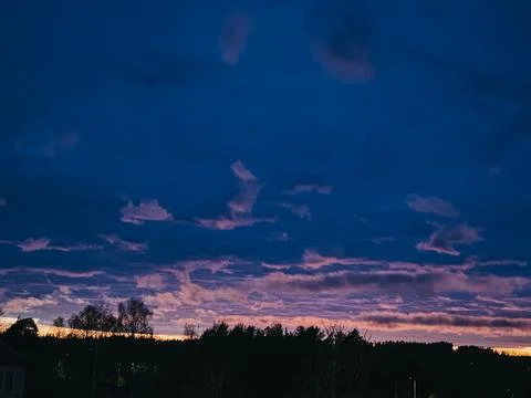 Dramatic Sunset Sky with Purple Clouds Over Forest Silhouette Stock Photos