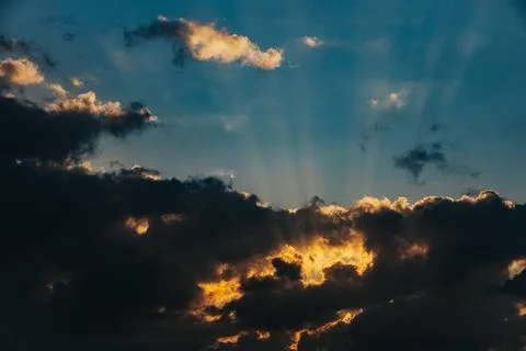 Dramatic sunset sky with rays of sunlight breaking through dark clouds, cre.. Stock Photos