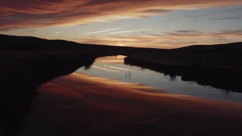 Dramatic sunset sky reflecting on calm river surface 스톡 동영상 333205032