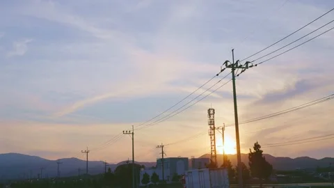 Dramatic sunset sky with silhouettes of utility poles and tower in Japan Stock Footage 337887452