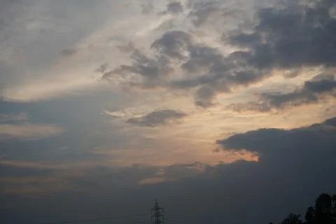 Dramatic sunset sky with soft clouds and golden light at dusk Stock Photos