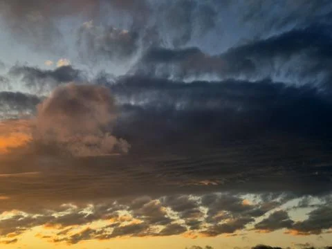 Dramatic sunset sky with storm clouds and glowing clouds 库存照片