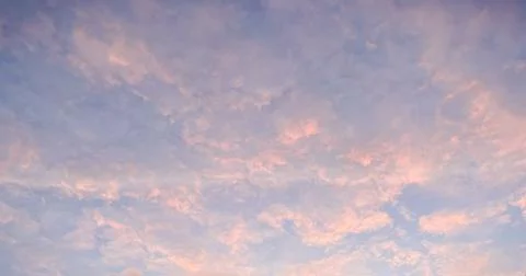 Dramatic sunset sky with textured clouds glowing in pink and orange colors .. Stock Photos