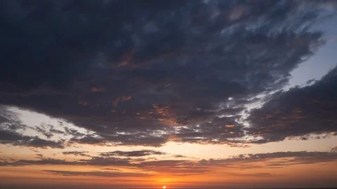 Dramatic sunset sky time lapse. Sun dropping below horizon with dark clouds. Video stock 115971738