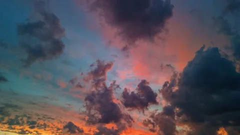 Dramatic sunset sky with vibrant clouds in shades of orange and blue, captured Stock Footage 299873542
