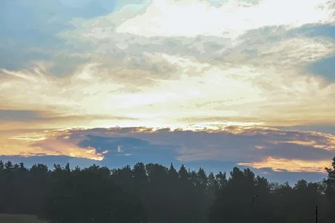 Dramatic sunset sky with vibrant clouds over a dark forest silhouette Fotos Stock