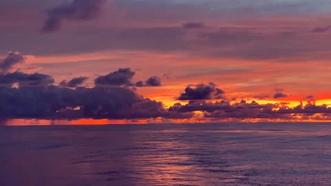 Dramatic sunset sky with vibrant colors over a calm ocean reflecting the ev.. Stock Footage 338280292