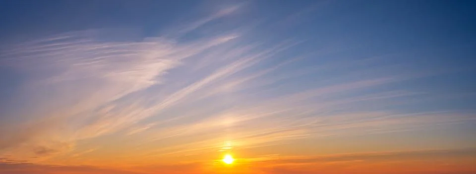Dramatic sunset sky with vibrant colors and soft clouds over the horizon Stock Photos