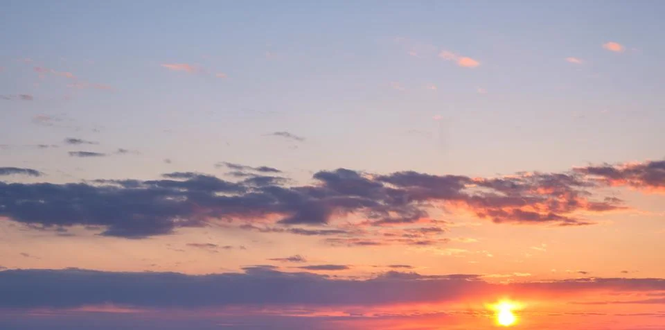 Dramatic sunset sky with vibrant colors and cloud formations at dusk Stock Photos