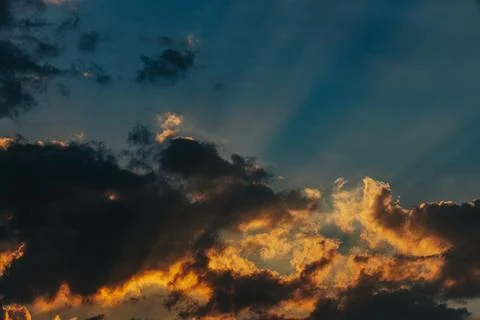 Dramatic sunset sky with vibrant orange and yellow hues illuminating dark c.. Stock Photos