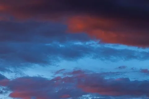 Dramatic sunset sky with vibrant orange and blue clouds creating a striking v Stock Photos