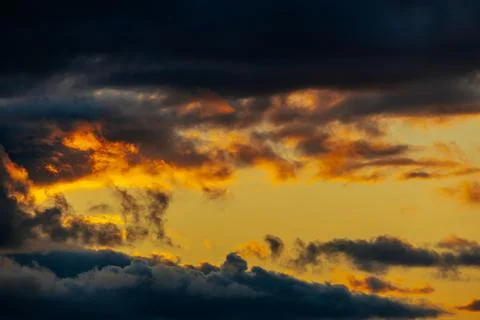 Dramatic sunset sky with vibrant orange and yellow hues contrasting against.. Stock Photos