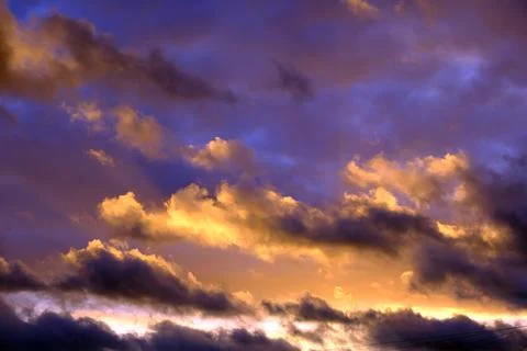 Dramatic Sunset Sky with Vibrant Purple and Golden Yellow Cumulus Clouds Foto stock