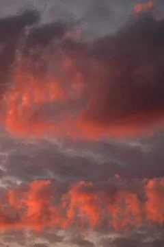 Dramatic sunset sky with vibrant red and orange glowing clouds and twilight Stock Photos
