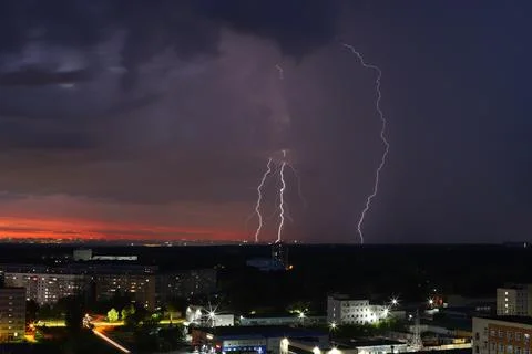 A dramatic sunset with storm clouds and rain over the cityscape Stock Photos