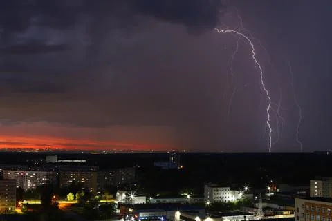 A dramatic sunset with storm clouds and rain over the cityscape Stock Photos
