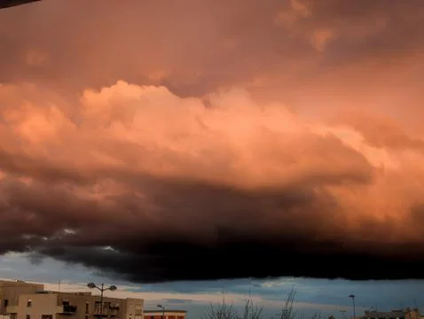 Dramatic Sunset Storm Clouds Over Cityscape Stock-Fotos