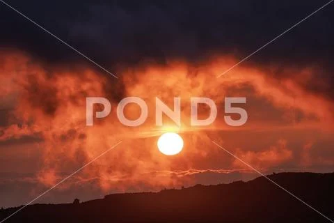 Dramatic sunset sun in clouds Stock Photos