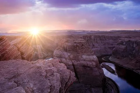 Dramatic sunset with sun rays in horseshoe bend canyon in Page Arizona Stock Photos