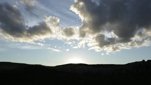 Dramatic Sunset Timelapse with Strong Lens Flare and Silhouetted Hills Stockbeeldmateriaal 321906285