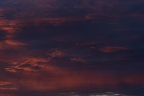 Dramatic sunset with vibrant clouds lit by a sun Stock Photos