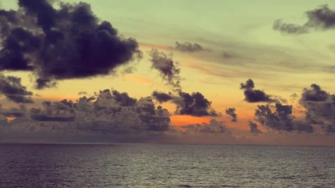 Dramatic sunset with vibrant clouds over a calm ocean horizon creating a se.. Stock Footage 338282608