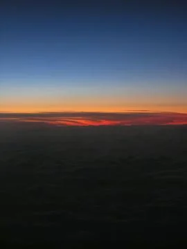 Dramatic sunset with vibrant orange and red sky fading into deep blue Stock Photos