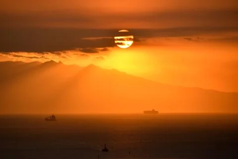 Dramatic sunset view with a silhouette of a mountain Stock Photos
