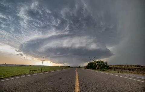  Dramatic supercell storm with a swirling cloud formation looms over an em... Stock Photos